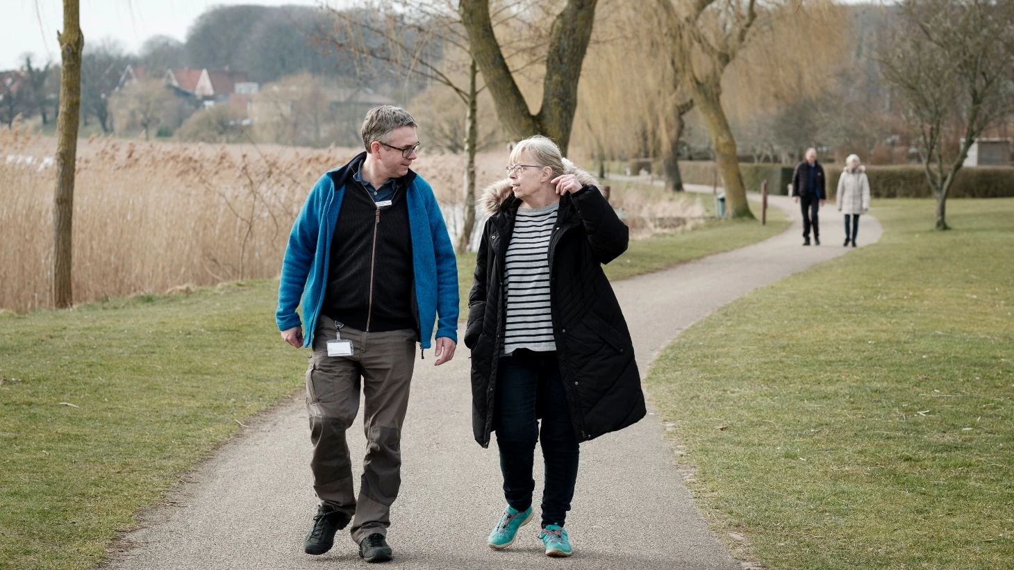 Pædagog går en tur med en patient på en sti