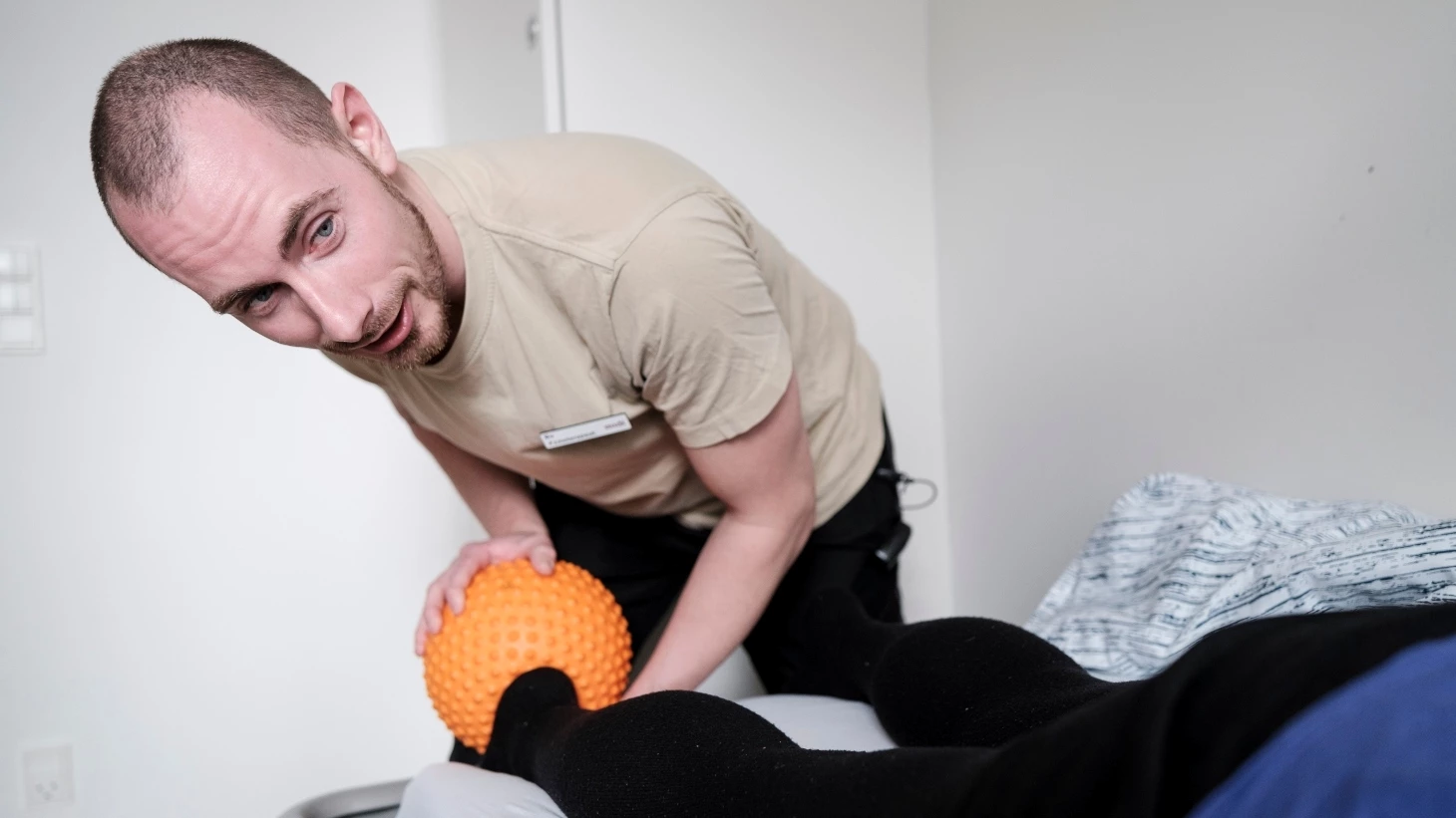 Fysioterapeut laver behandling med ballstick-massage
