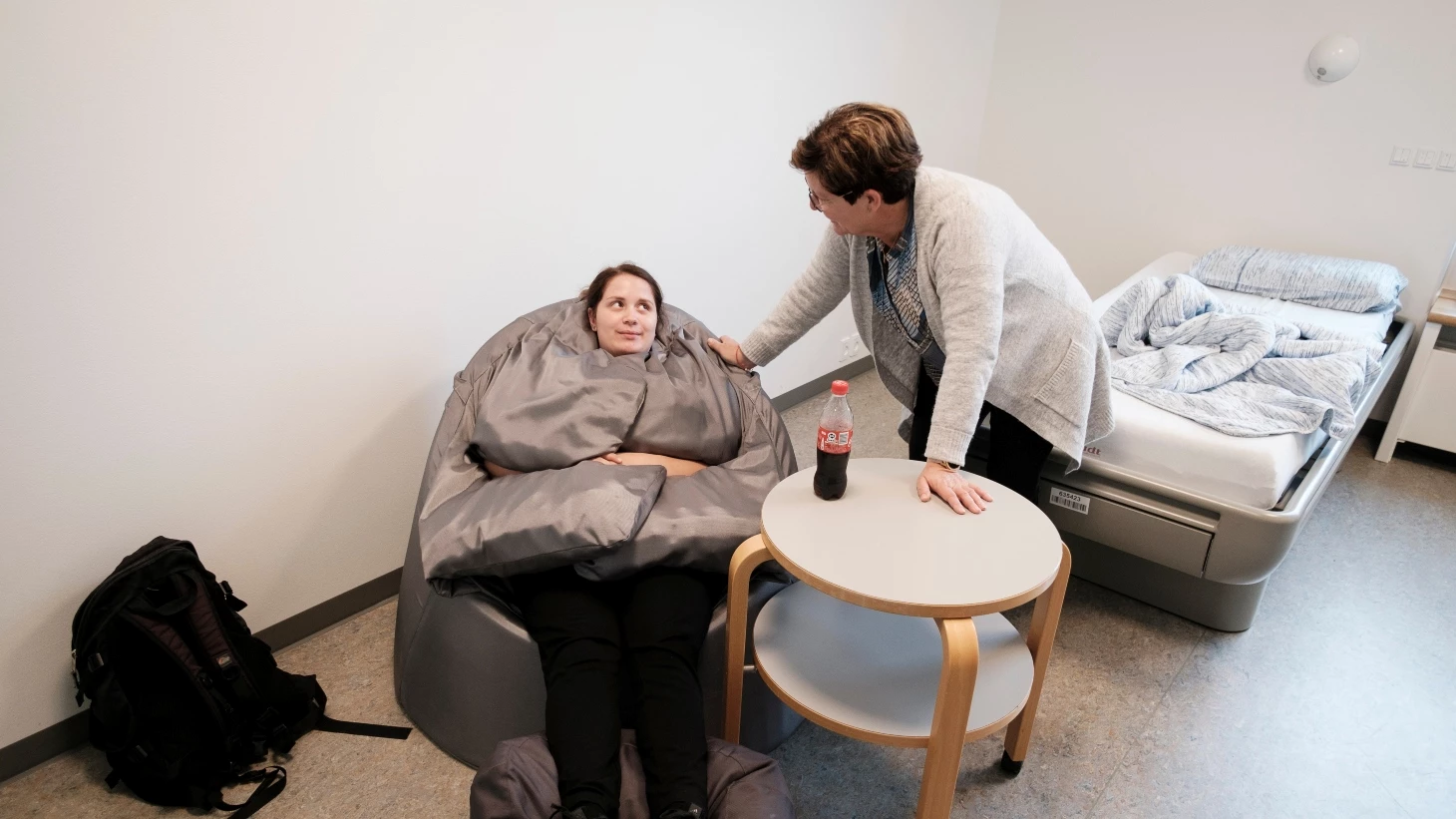 Social- og sundhedsassistent ser til en patient, der sidder i en tyngdestol